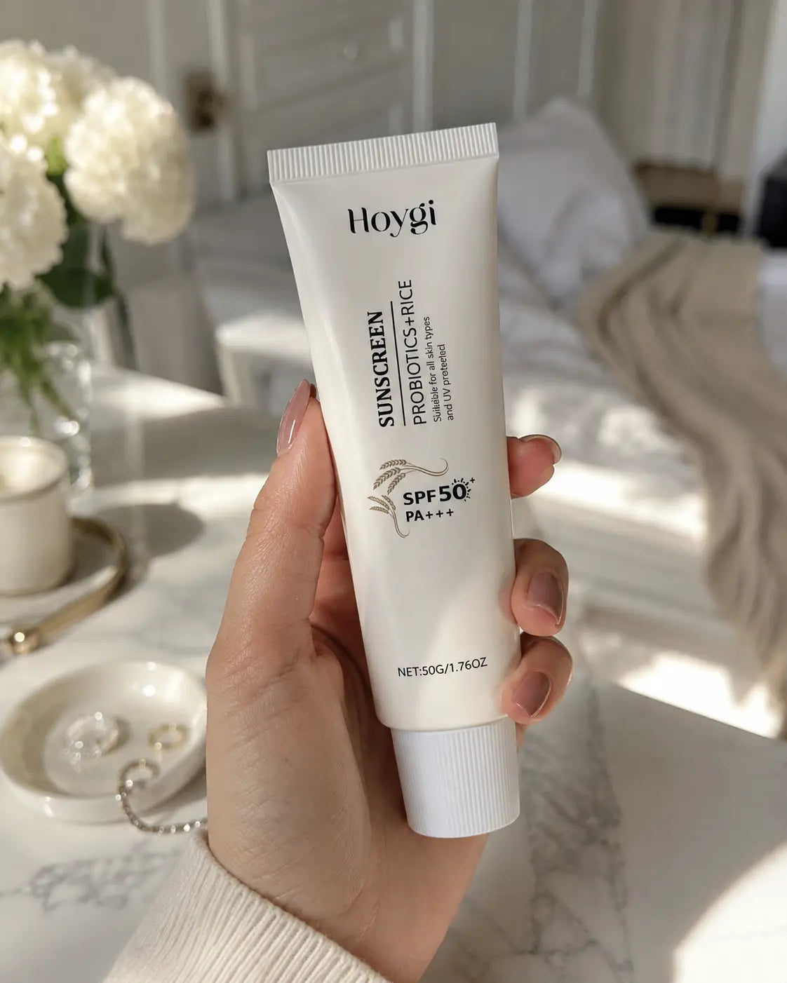 Frau hält Velivor Daily Defense SPF 50 Sonnenschutz in einem hellen Zuhause mit weichem natürlichem Licht