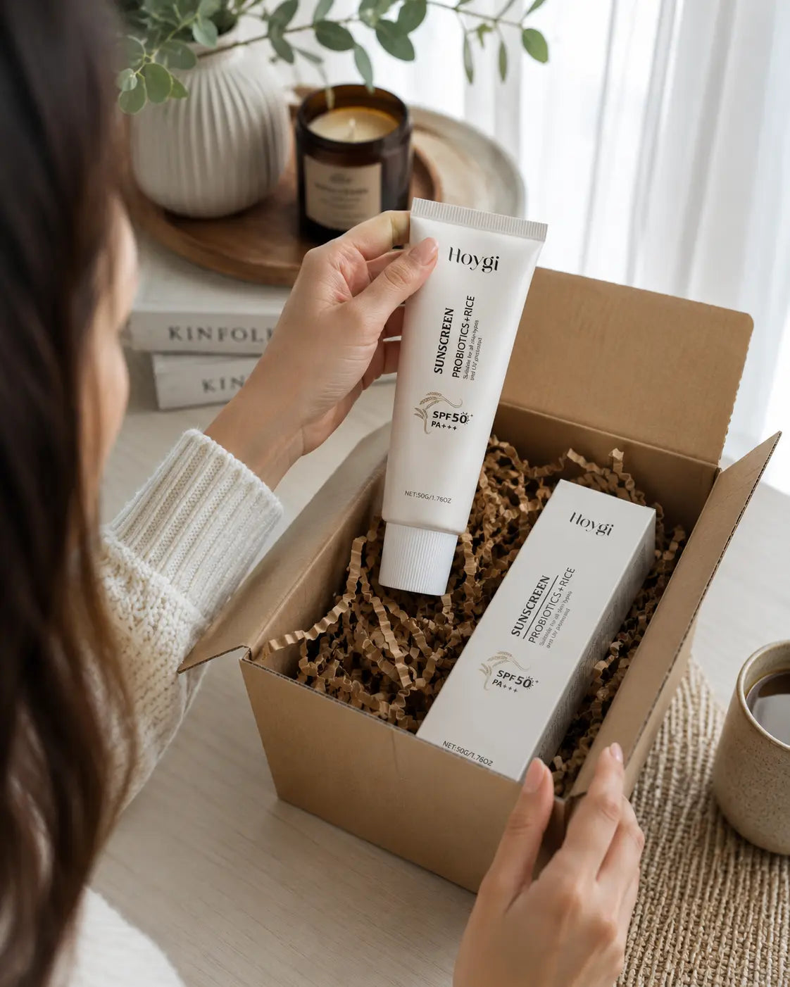 Frau packt den Velivor Daily Defense SPF 50 Sonnenschutz mit Produktbox und Tubenverpackung aus.